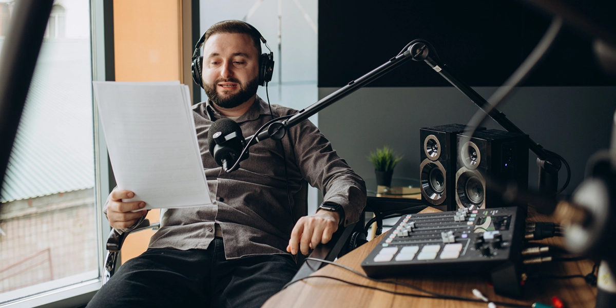 Animateur radio en studio lisant son script au micro à Caen