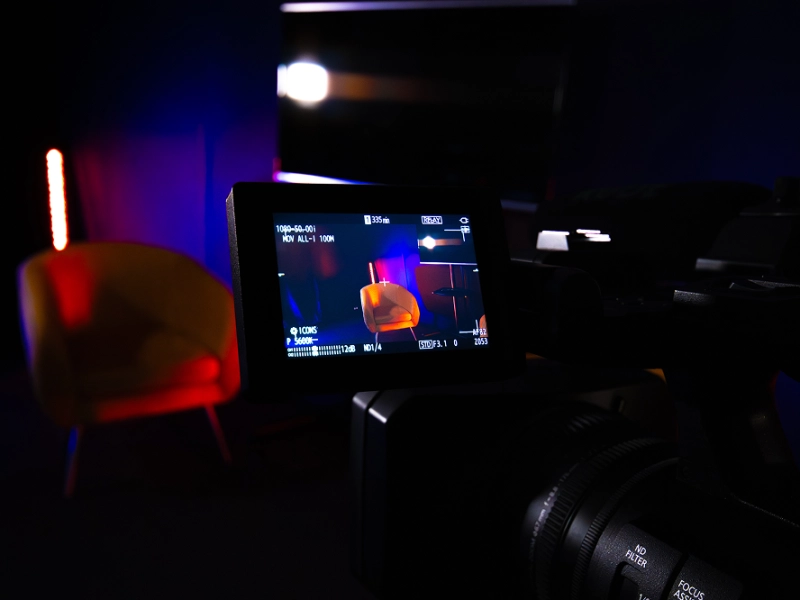 Gros plan sur l'écran de contrôle d'une caméra professionnelle affichant les réglages de prise de vue lors d'un exercice pratique en studio