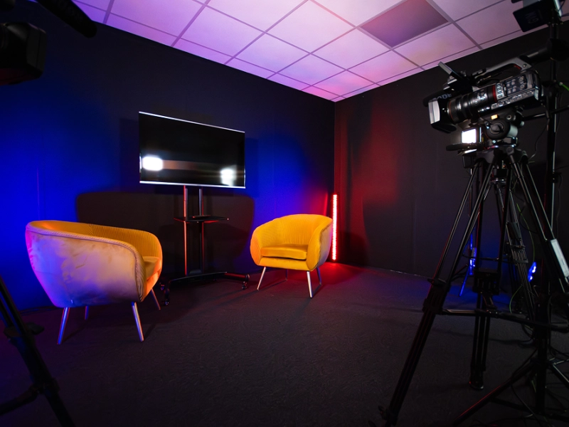 Plateau TV configuration interview avec deux fauteuils et caméras pour la formation aux techniques d'entretien journalistique