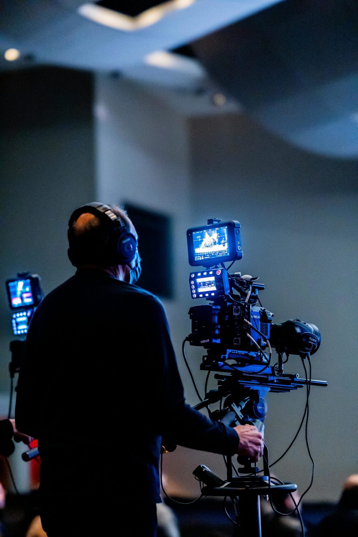 Cameraman filmant un événement en intérieur.