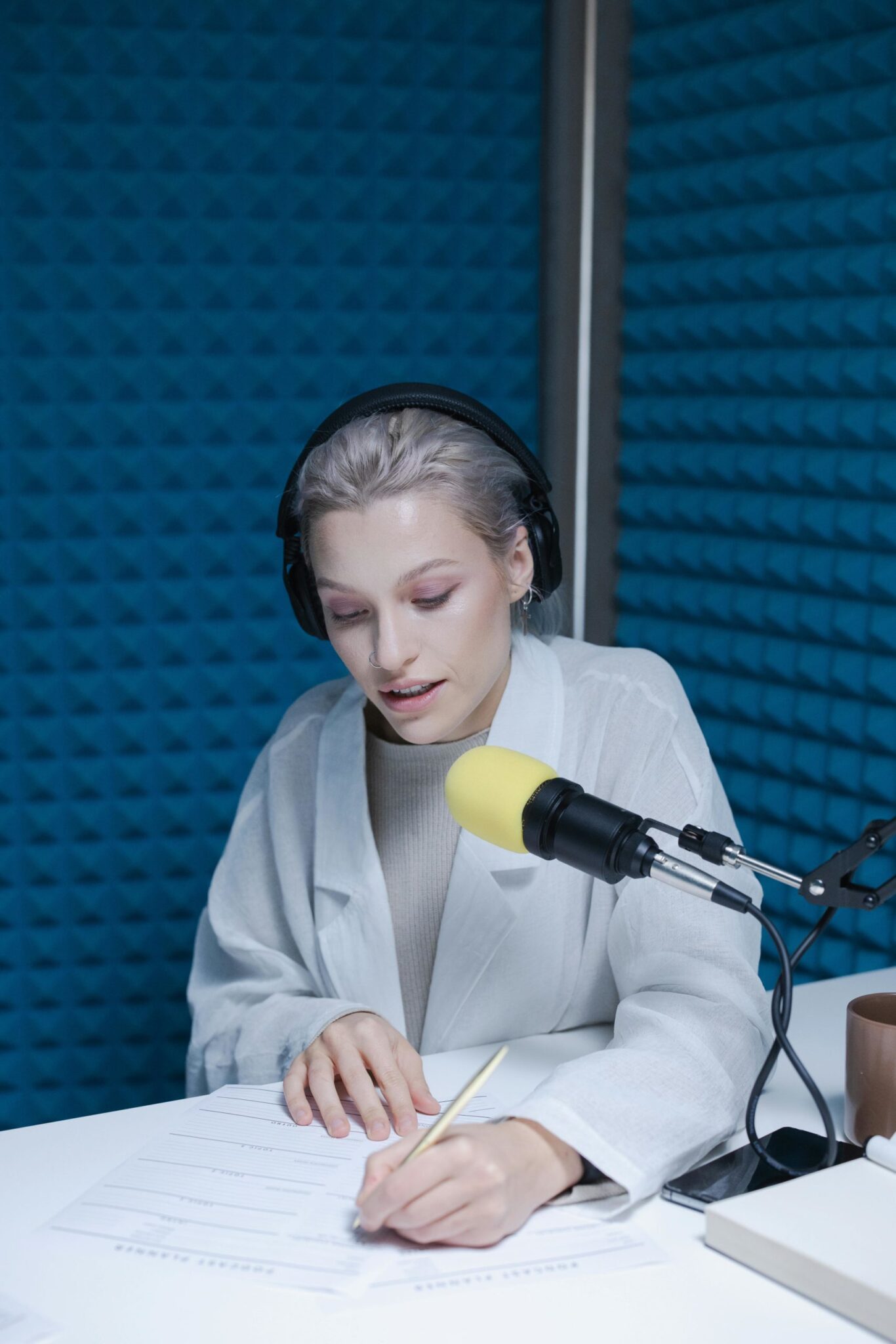 Personne dans un studio d'enregistrement avec un micro jaune.