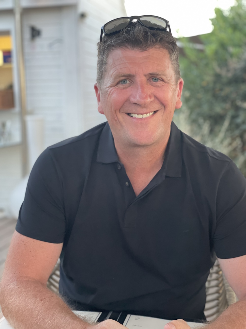 bruno Homme souriant en chemise noire tenant un menu.