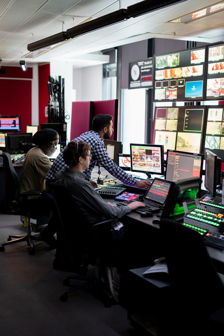 Techniciens travaillant dans un studio de contrôle audiovisuel.